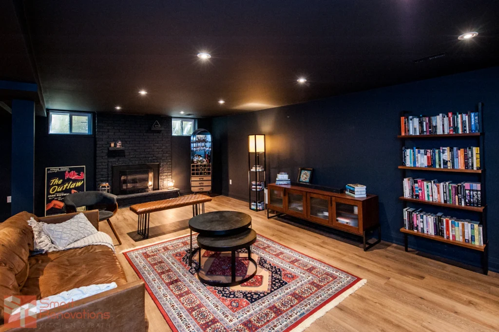 Finished basement media room with deep wall colour, built-in shelving and lounge seating