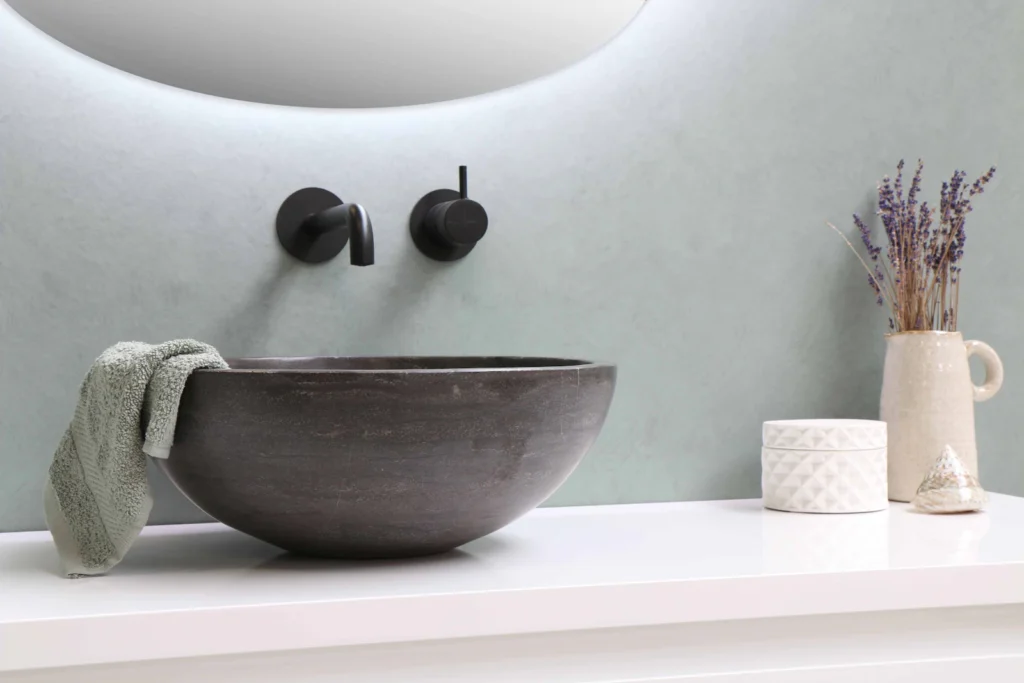 Stone vessel sink with matte black wall-mounted faucet