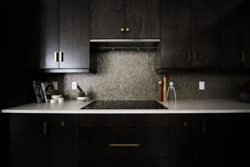 Custom black cabinetry with integrated lighting and stone backsplash