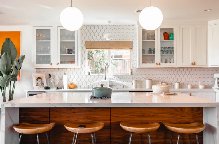 Modern kitchen with white quartz island, warm wood base and pendant lighting