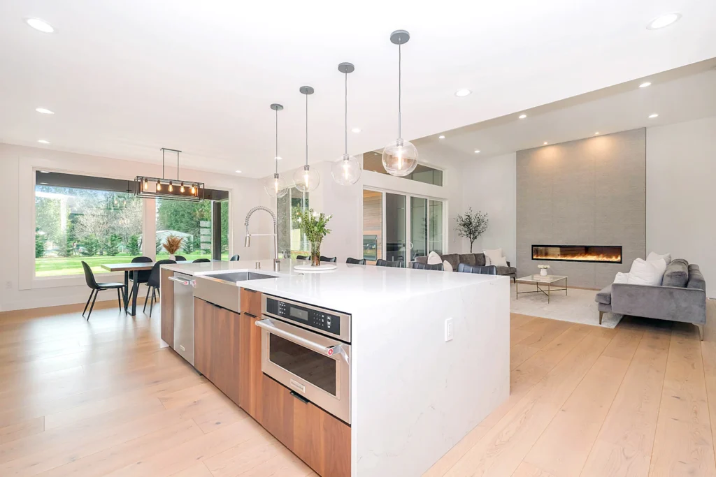 Open-plan kitchen and living space with white island and wood floors