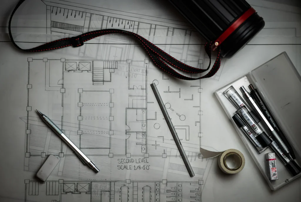 Architectural floor plan with drafting tools on a desk